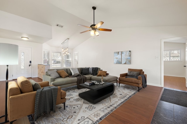 living room featuring lofted ceiling, ceiling fan with notable chandelier, and light hardwood / wood-style floors