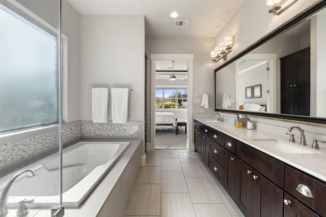 bathroom with vanity and tiled bath