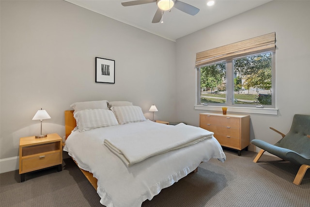 bedroom with ceiling fan and dark colored carpet