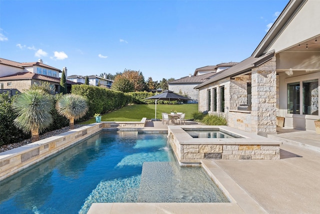 view of pool with a patio area, a lawn, pool water feature, and an in ground hot tub