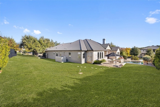 rear view of property with a patio and a lawn