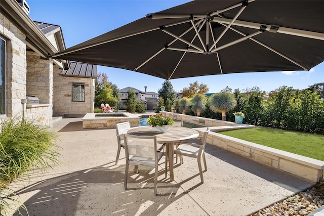 view of patio / terrace featuring area for grilling and a swimming pool with hot tub