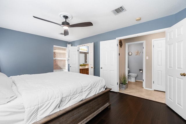 bedroom featuring ceiling fan, ensuite bath, and hardwood / wood-style flooring