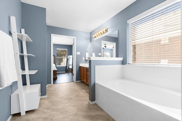 bathroom featuring vanity, tile patterned floors, and a tub to relax in