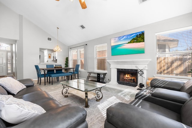 living room featuring light colored carpet, high vaulted ceiling, and ceiling fan with notable chandelier