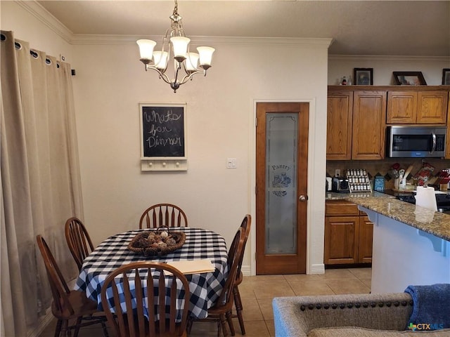 kitchen featuring decorative light fixtures, ornamental molding, light tile patterned floors, light stone countertops, and an inviting chandelier