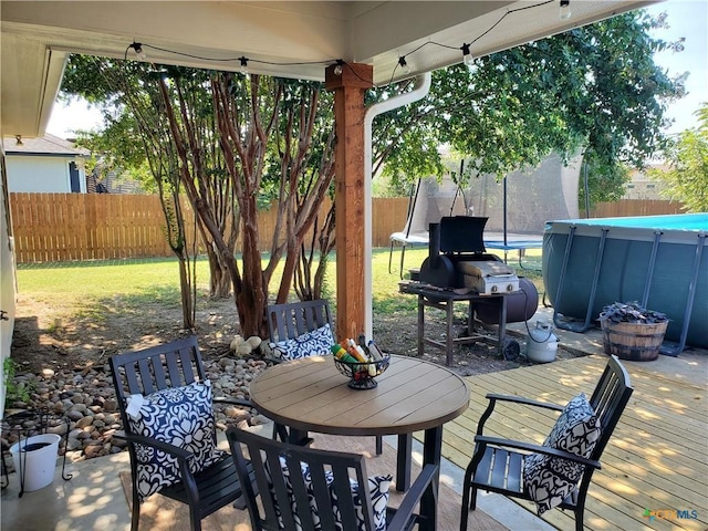 view of patio featuring a swimming pool side deck and a grill