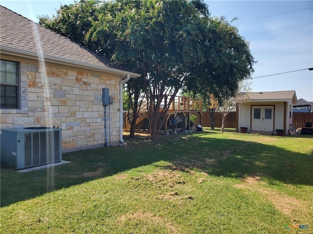 view of yard featuring central AC unit and a storage shed