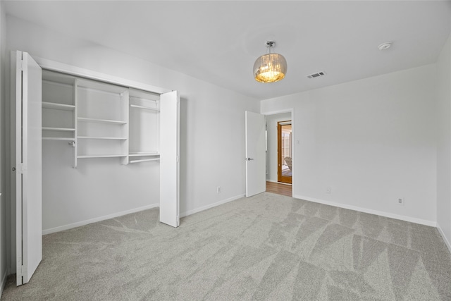 unfurnished bedroom featuring light colored carpet and a closet