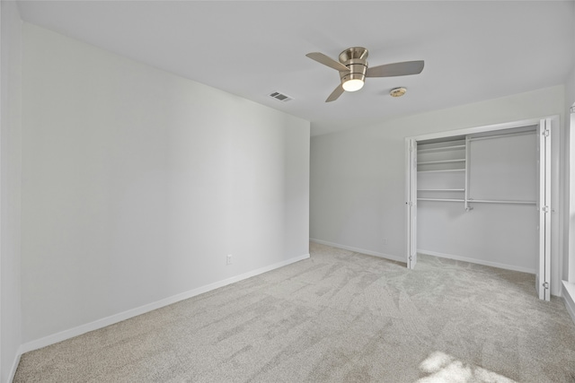 unfurnished bedroom featuring light colored carpet, ceiling fan, and a closet