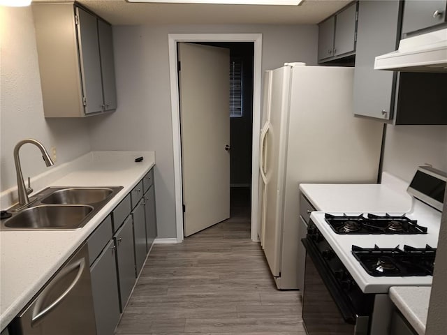 kitchen with gray cabinets, sink, stainless steel dishwasher, gas range, and light hardwood / wood-style flooring