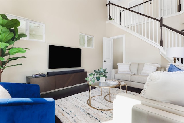 living room featuring hardwood / wood-style flooring and a high ceiling