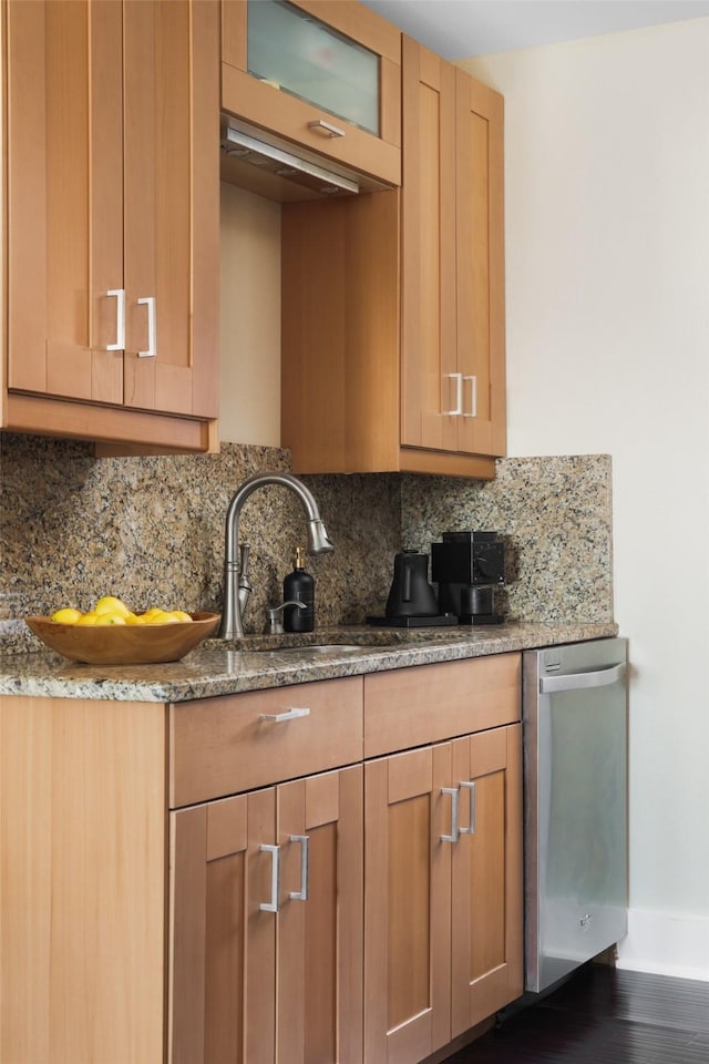 kitchen featuring dark hardwood / wood-style flooring, light stone countertops, sink, and decorative backsplash