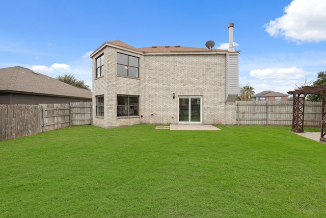 rear view of house featuring a lawn and a patio