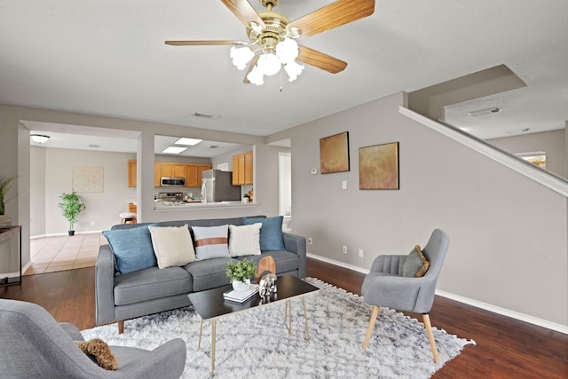 living room featuring ceiling fan and dark hardwood / wood-style flooring