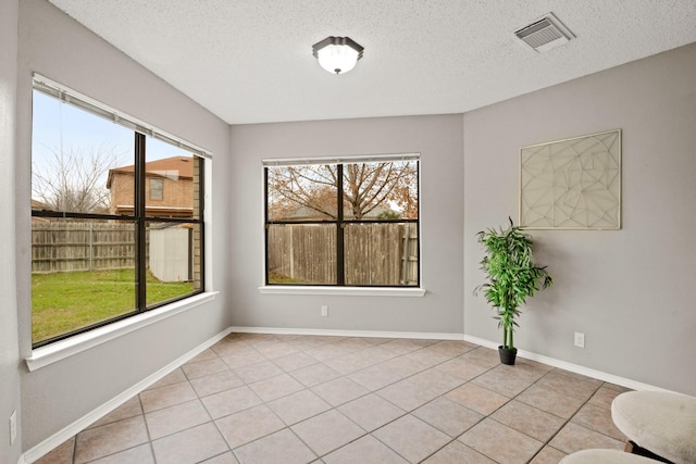 interior space with light tile patterned floors and a textured ceiling