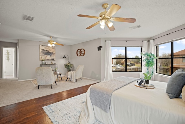 bedroom featuring wood-type flooring, a textured ceiling, and ceiling fan