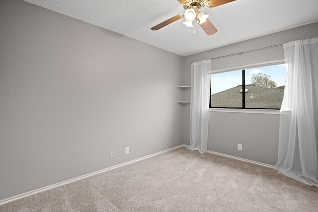 spare room featuring ceiling fan, light carpet, and a textured ceiling