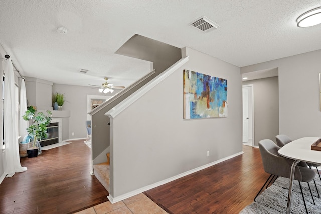 tiled dining space featuring ceiling fan and a textured ceiling