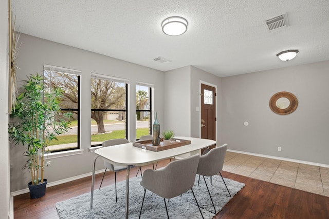 dining room featuring hardwood / wood-style floors, a wealth of natural light, and a textured ceiling