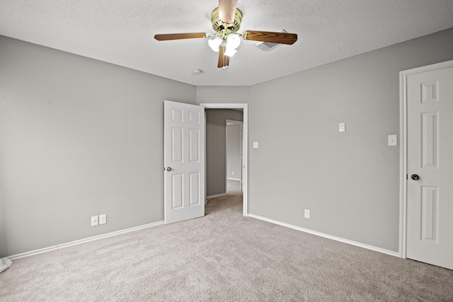 unfurnished room with light carpet, ceiling fan, and a textured ceiling