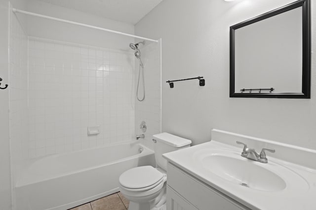 full bathroom with tile patterned floors, toilet, tiled shower / bath, a textured ceiling, and vanity