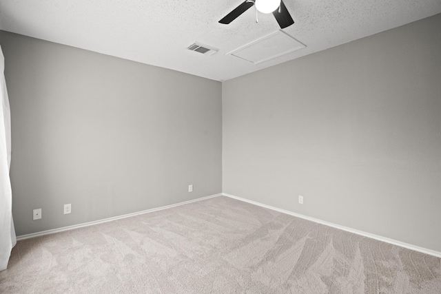 carpeted spare room featuring ceiling fan and a textured ceiling