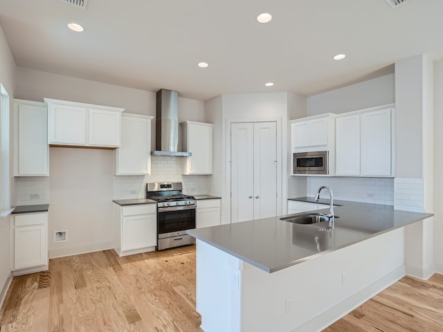 kitchen with sink, white cabinets, wall chimney exhaust hood, and appliances with stainless steel finishes