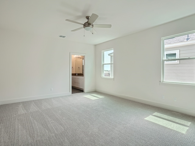 carpeted empty room with plenty of natural light and ceiling fan