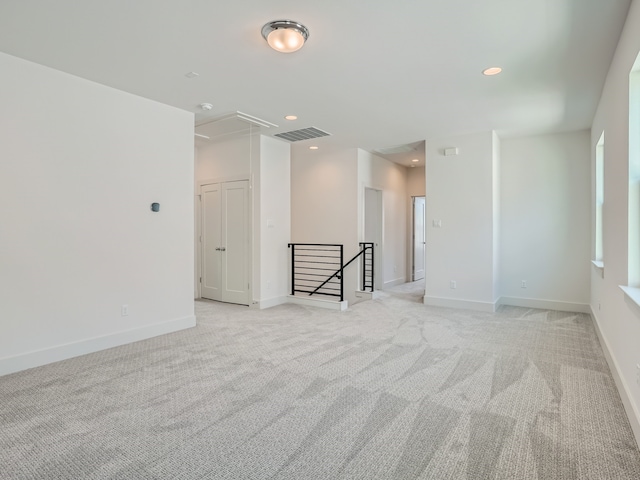 spare room featuring light carpet