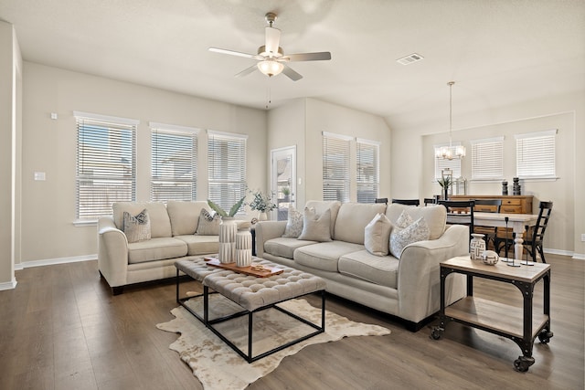 living room with dark wood-type flooring and ceiling fan with notable chandelier