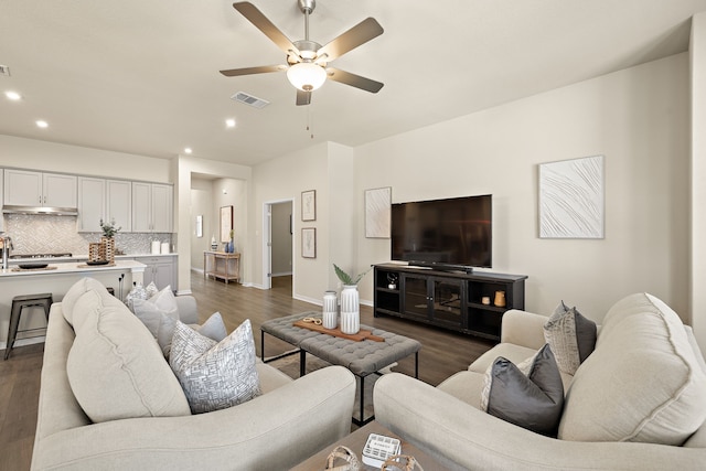 living room featuring dark hardwood / wood-style flooring, sink, and ceiling fan