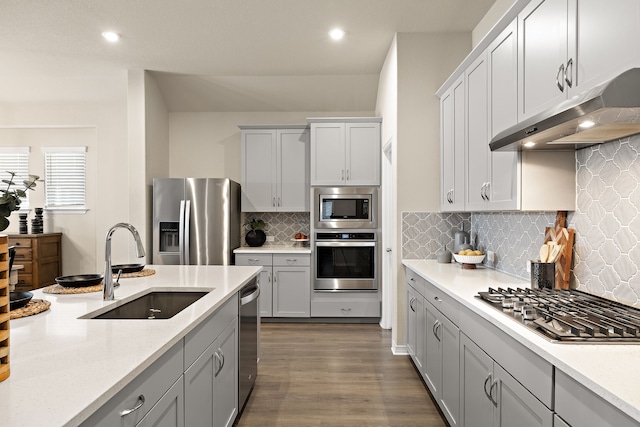 kitchen with tasteful backsplash, sink, stainless steel appliances, and dark hardwood / wood-style floors