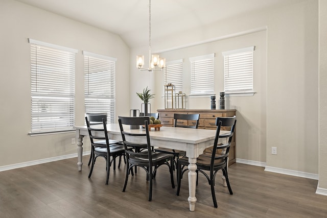 dining space with dark wood-type flooring, a notable chandelier, lofted ceiling, and a wealth of natural light