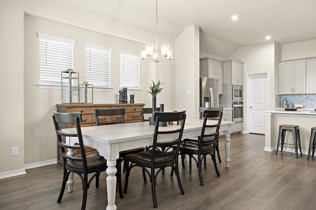 dining room featuring lofted ceiling, dark hardwood / wood-style flooring, and a chandelier