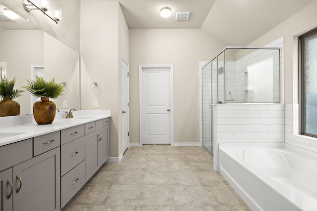 bathroom with vanity, a wealth of natural light, lofted ceiling, and independent shower and bath