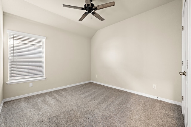 empty room featuring lofted ceiling, carpet floors, and ceiling fan