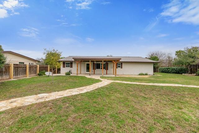 ranch-style house with a patio and a front lawn