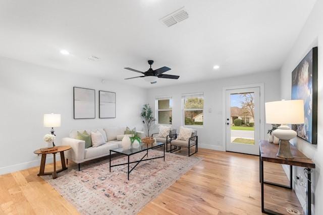 living room featuring light hardwood / wood-style flooring and ceiling fan