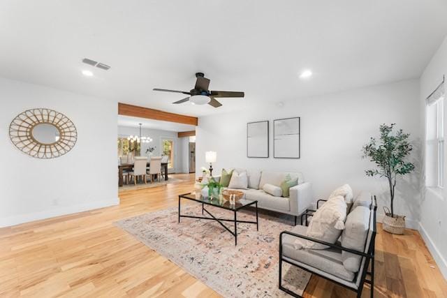 living room with hardwood / wood-style floors and ceiling fan with notable chandelier