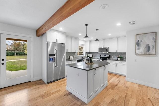 kitchen with white cabinetry, appliances with stainless steel finishes, beam ceiling, and hanging light fixtures