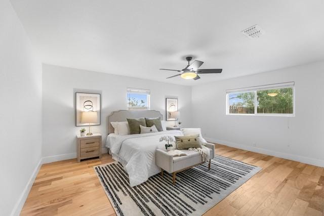 bedroom with multiple windows, ceiling fan, and light hardwood / wood-style floors