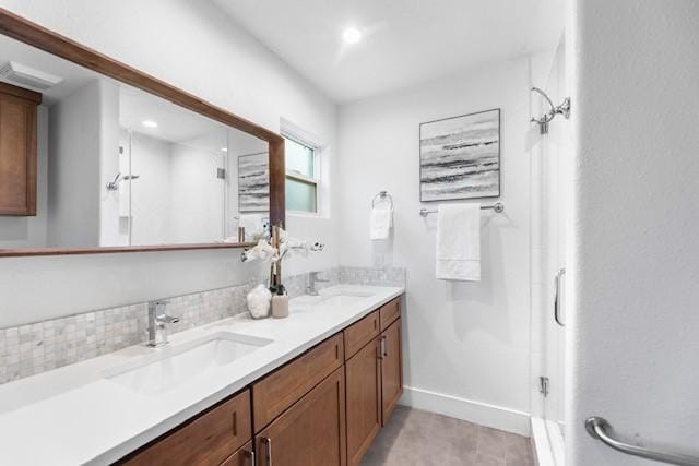 bathroom featuring vanity, decorative backsplash, and a shower with shower door