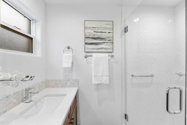 bathroom featuring vanity and a shower with door