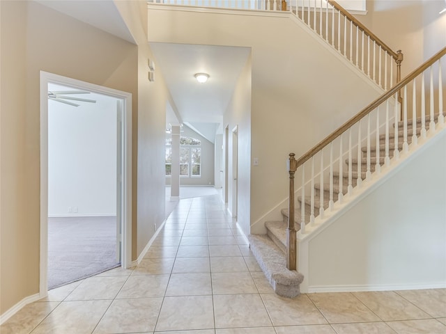 foyer entrance featuring lofted ceiling, light tile patterned floors, and ceiling fan