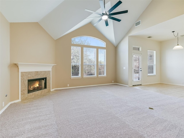 unfurnished living room featuring lofted ceiling, a fireplace, light colored carpet, and ceiling fan