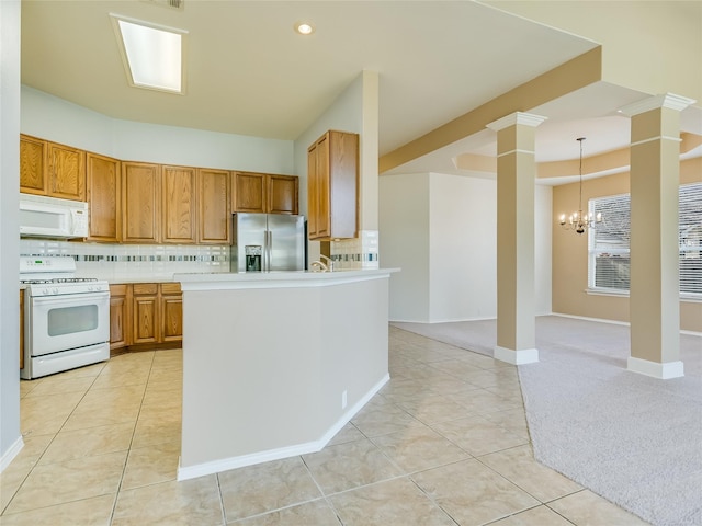 kitchen with pendant lighting, decorative columns, tasteful backsplash, light tile patterned floors, and white appliances