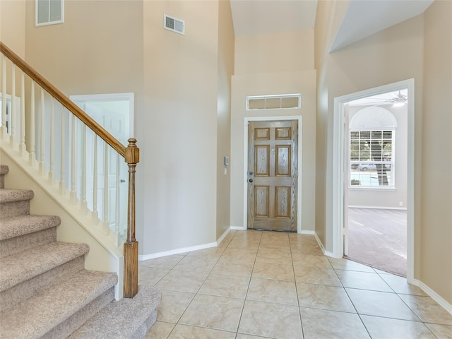 foyer with light tile patterned flooring and a towering ceiling