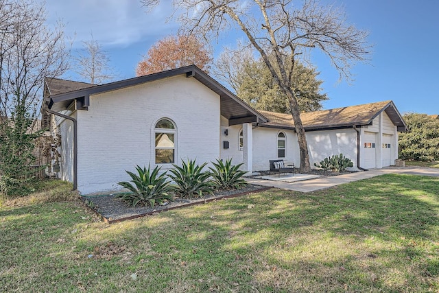 view of front facade featuring a garage, a front yard, and a patio area