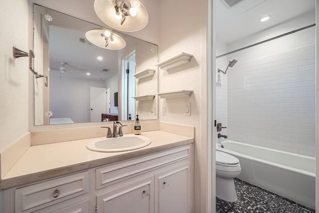 full bathroom featuring tiled shower / bath, vanity, toilet, and tile patterned floors